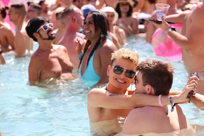 A couple in sunglasses embracing in the pool.