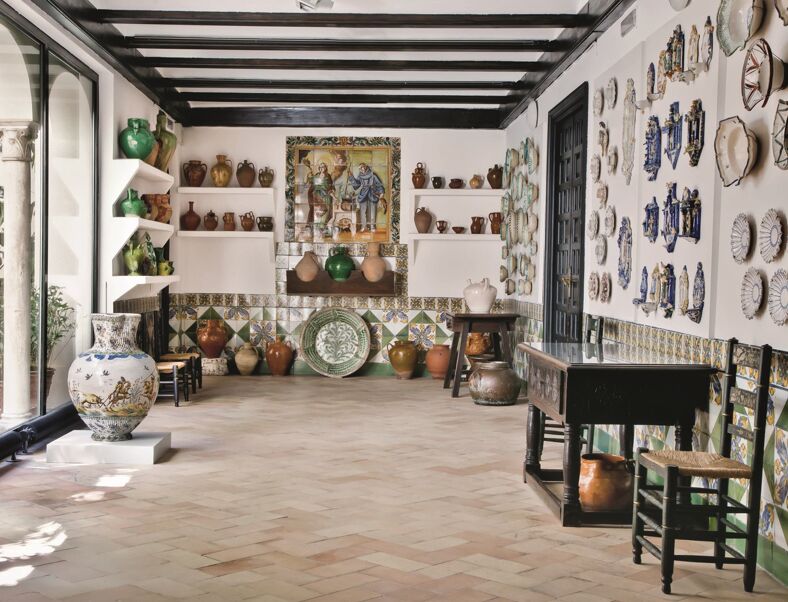 Room in the Soralla museum covered in colorful ceramics and antique wooden furniture.