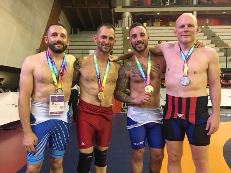 Four Gay Games medalists standing side by side, posing for the camera.