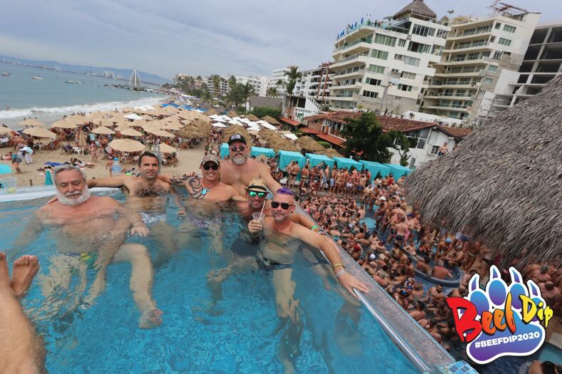Six men in a pool overlooking a party below.
