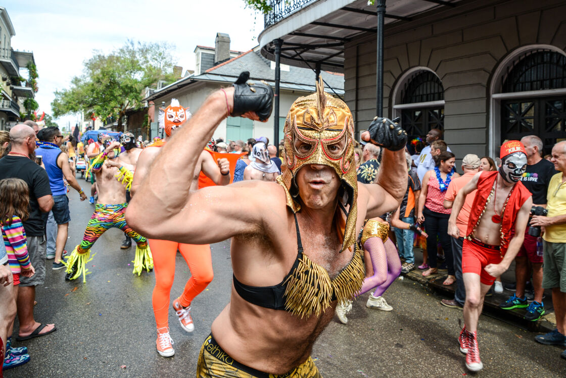 Scantily clad men in masks parade through the streets of New Orleans.