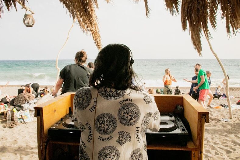 A DJ performs on the beach at Queer Ranch Festival in Greece