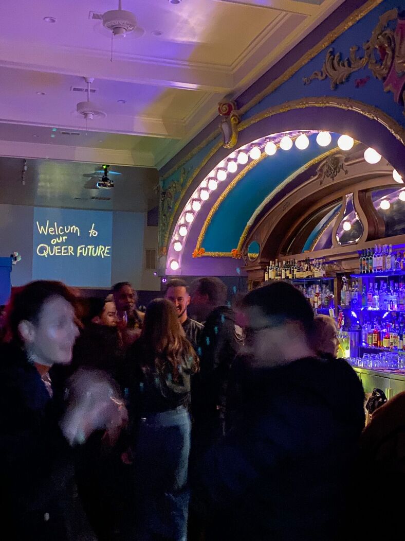 Inside Mother, the ornate mulit-colored bar resembles a cinema marquee. A bouquet of queers mingle under a sign that says 