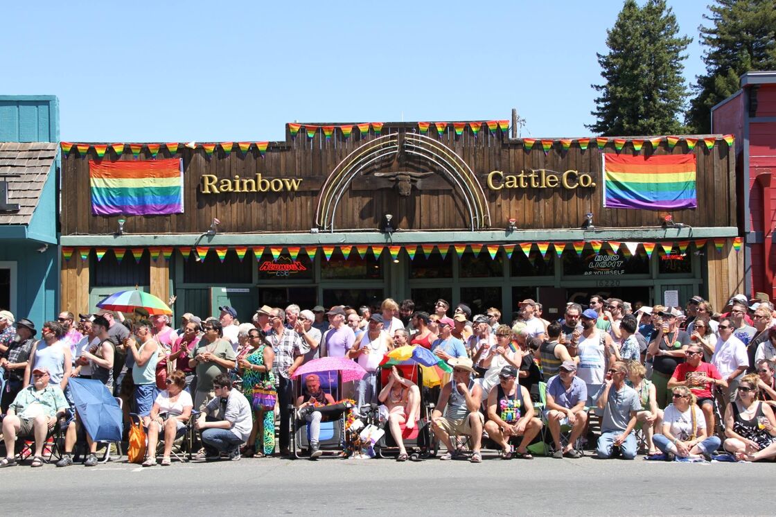 A crowd gathers outside of the Rainbow Cattle Company during the town's annual Pride Parade. 