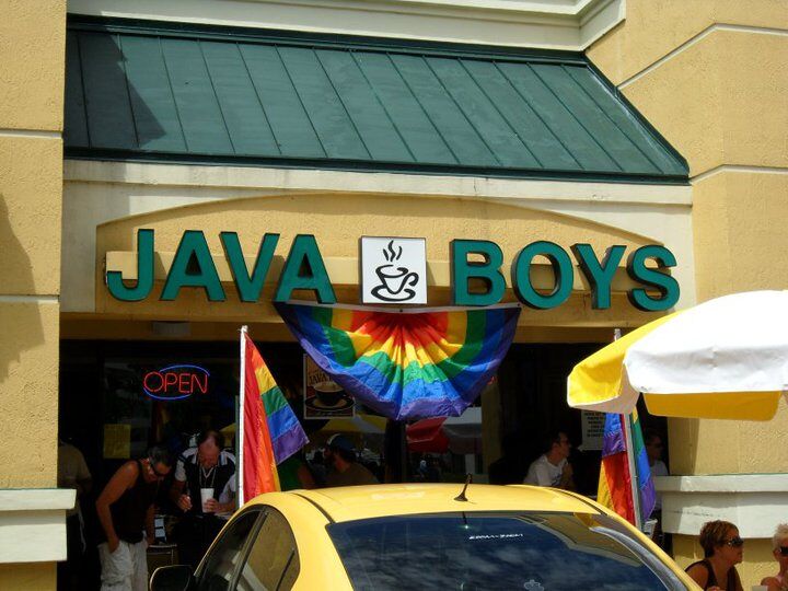 The Java boys sign has a large rainbow flag under its name with patrons drinking coffee in the Florida sunshine. 