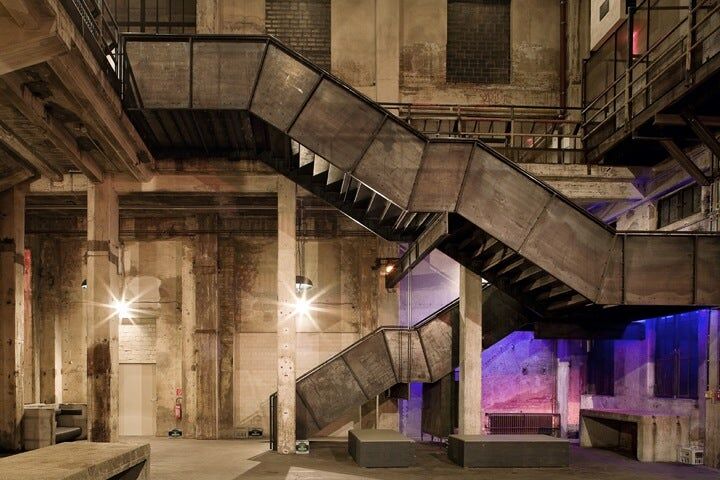 A view inside Berghain, cement pillars  and a steel staircase.