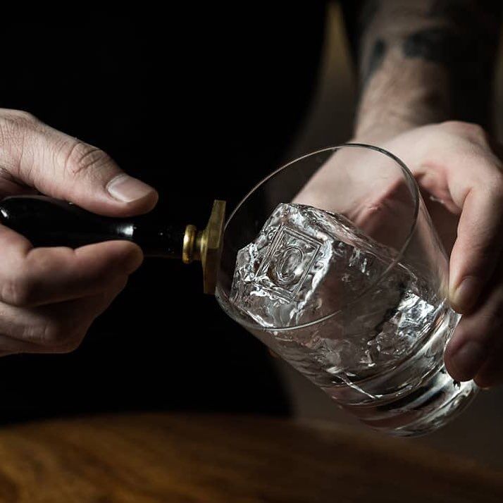 A mixologist at Cloakroom Bar stamps the ice cube before making a cocktail.