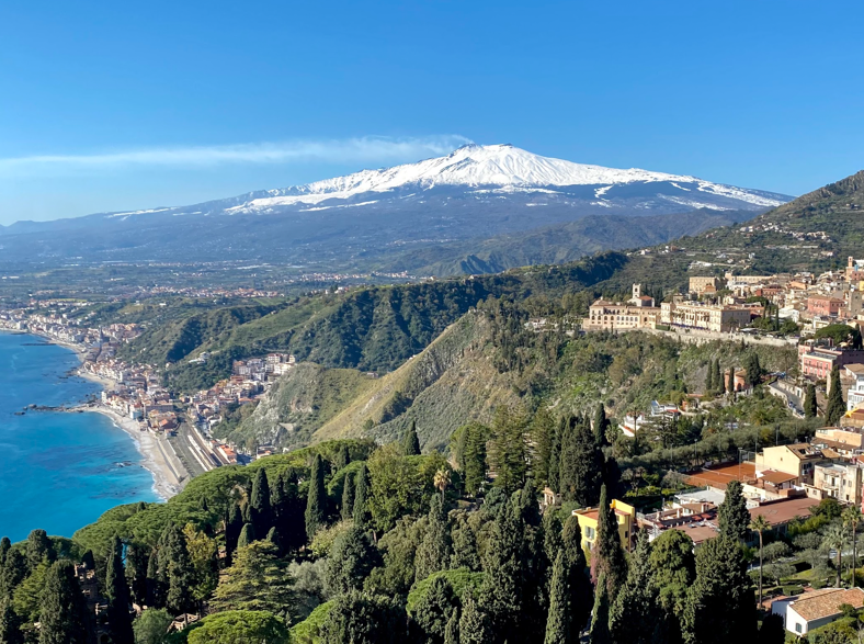 A view of Mount Etna covered in snow overlooking Sicily's eastern coast.