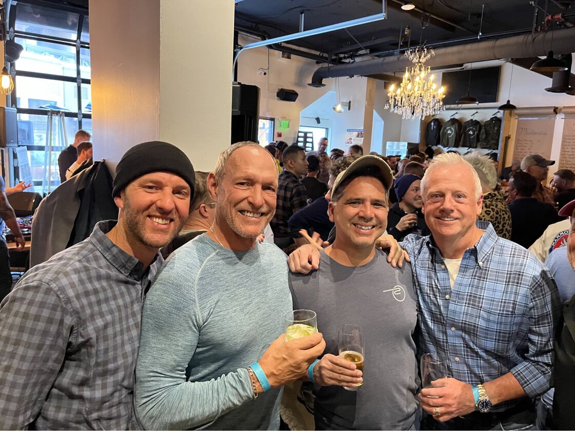 A group of older men posing for the camera inside a bar.