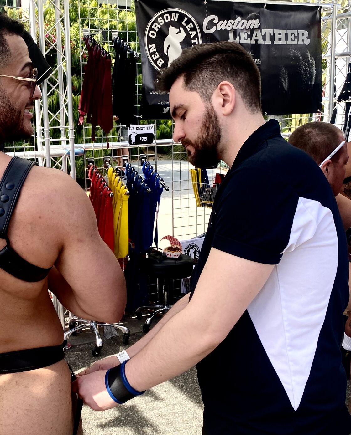 Logan Cuccia fitting a kinky customer's new jockstrap at the Ben Orson Leather booth.