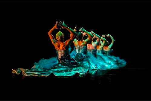 Male dancers in corsets and teal tutus.