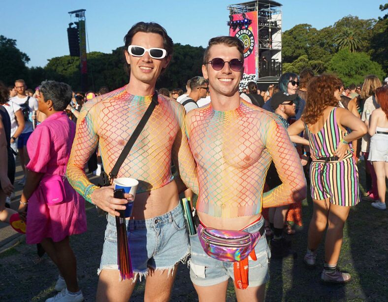 Two men wearing rainbow fishnet crop tops at Sydney WorldPride.