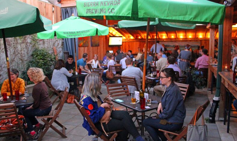 Diners sit outside under sun umbrellas at the Albert Street Pub.