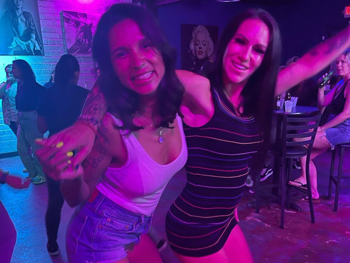 Two ladies embrace as they smile for the camera inside Boycott Bar in Phoenix. 