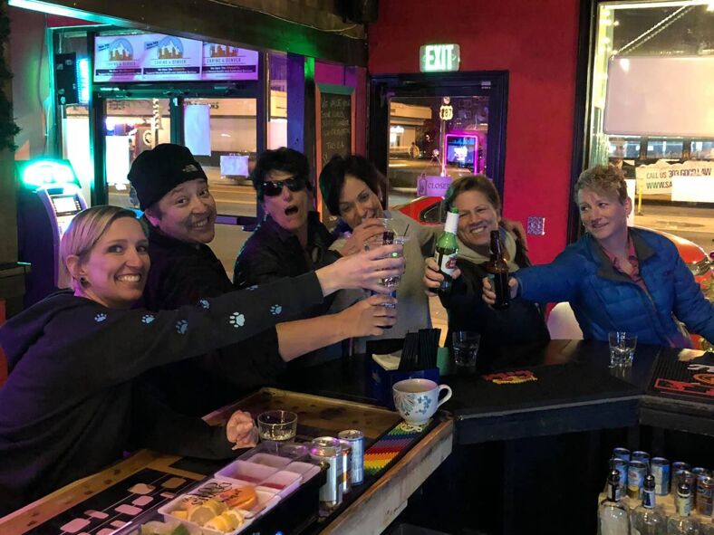 A group of friends cheering at the bar.