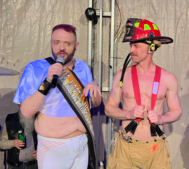 The emcee at the Leather Stallion Saloon asks attendees to rate a firefighter outfit.