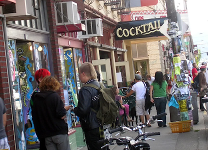 A street view from Hawthorne Blvd with people on the sidewalk and businesses lining the street.