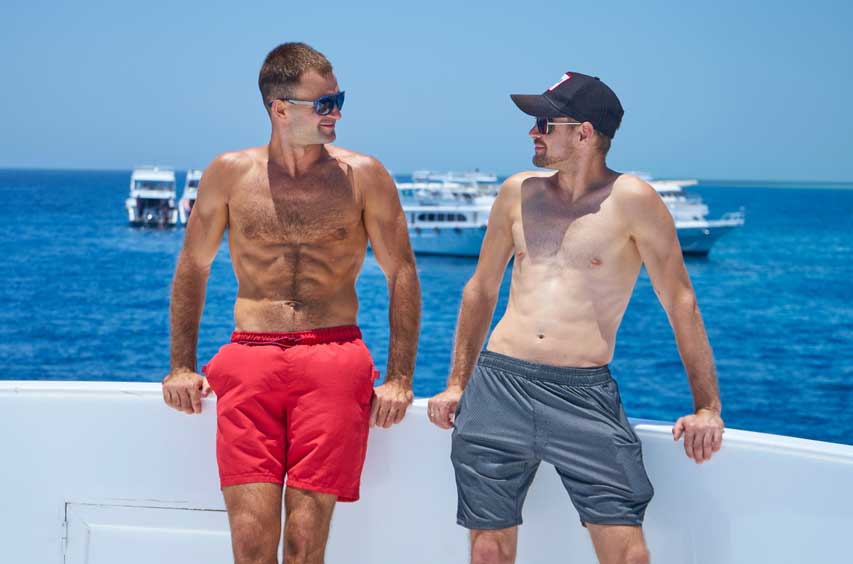 Two shirtless men on a boat.