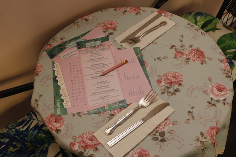 A table set with utensils, a menu, and a pencil.