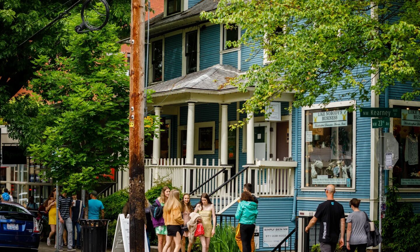 A view of a shop in the Northwest district with several people standing around on the sidewalk.