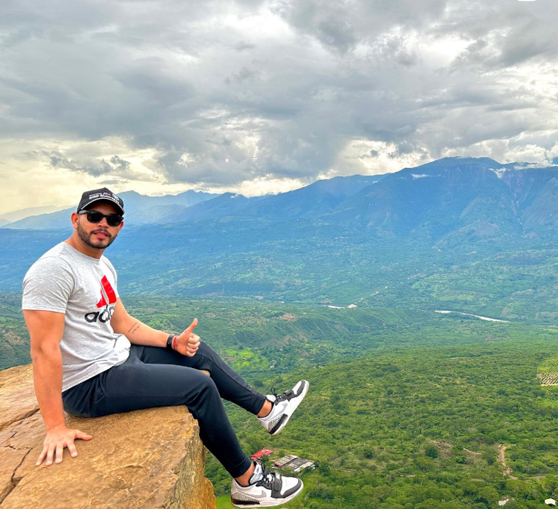 A tourist poses at Salto del Mico withe a view of the Andes in the background