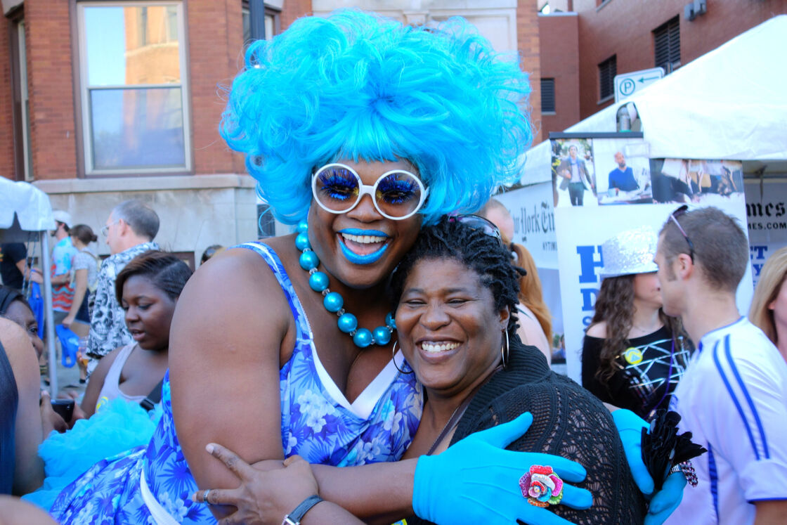 A drag queen in bright blue poses with an attendee at Chicago's Market Days even in August