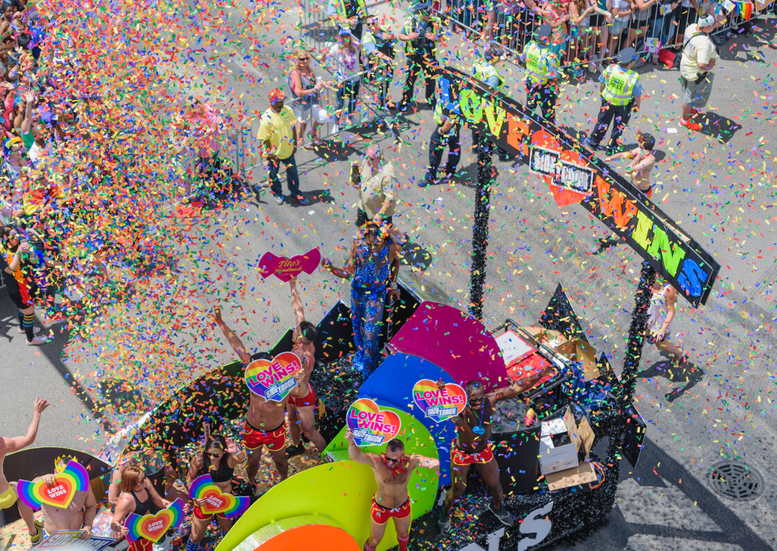 a Chicago Pride Parade float with colorful rainbow confetti in the air and people dancing