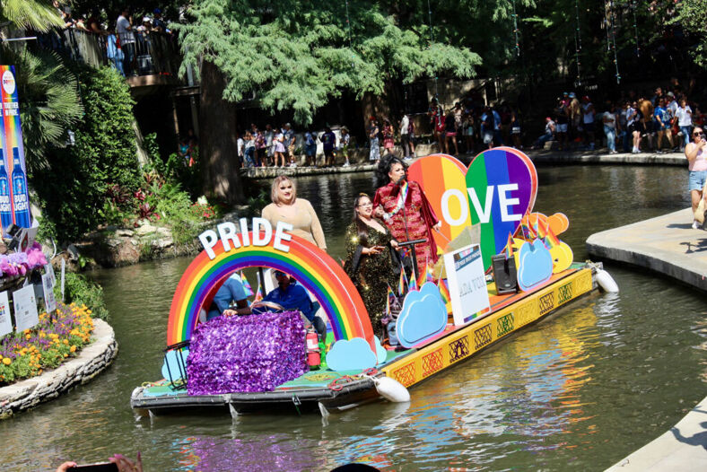 A rainbow pride float makes its way down the river