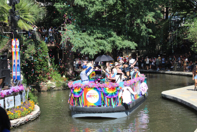 A float filled with dancing people and a DJ booth 