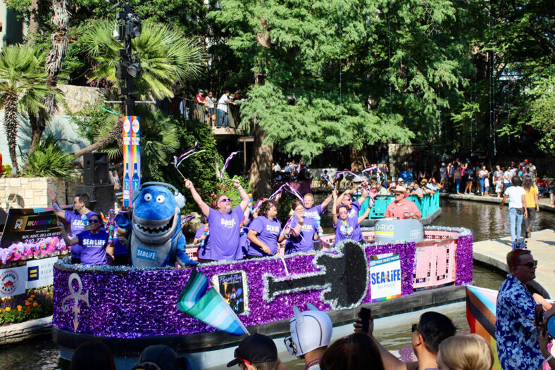 A purple Prince inspired float with a shark mascot dancing in the front