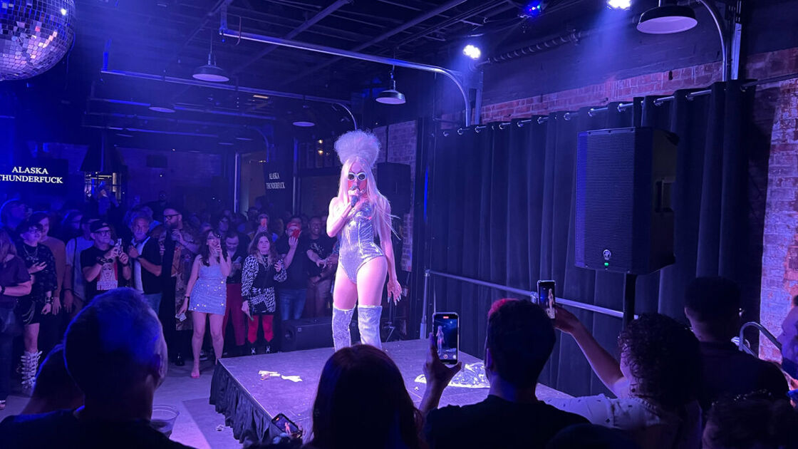 Drag queen performers in a silver body suit