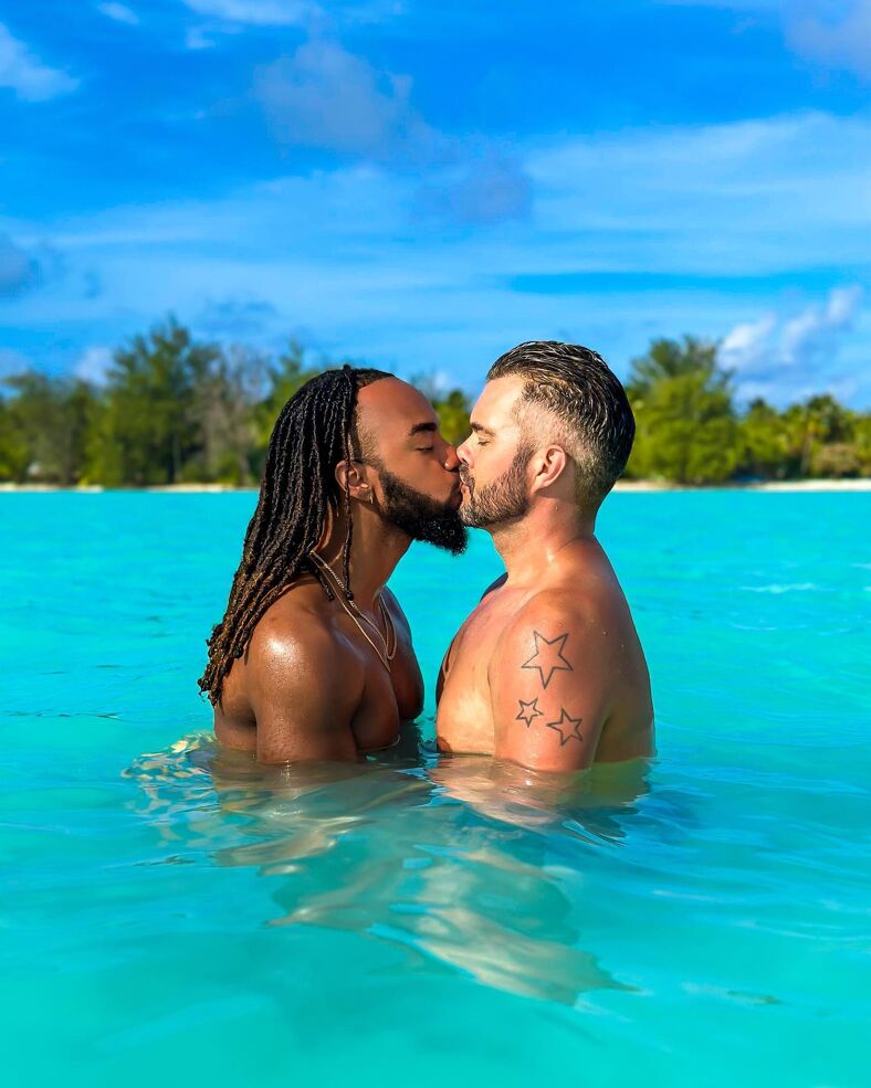 Emile and AJ kissing in the ocean.