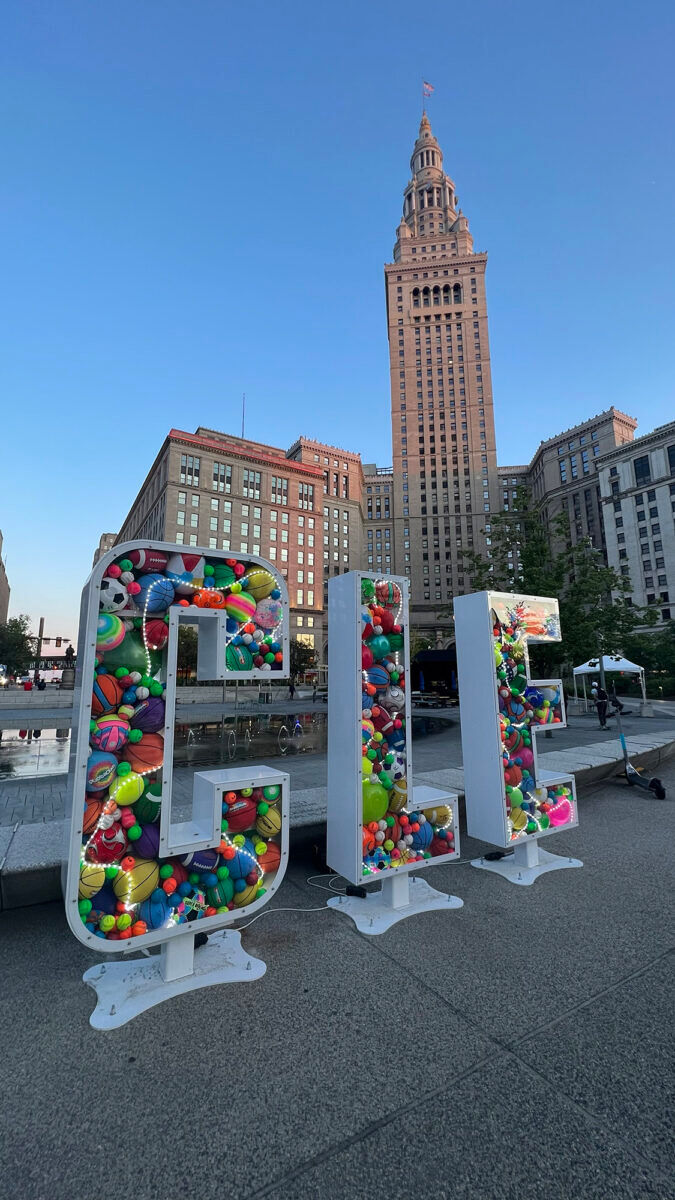 Colorful CLE letters in front of a large tower