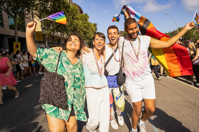 A group of friends holding Pride flags.