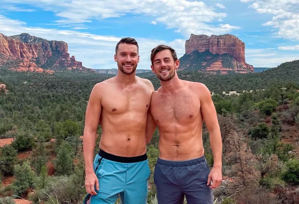 Shirtless couple stands in front of the Arizona landscape