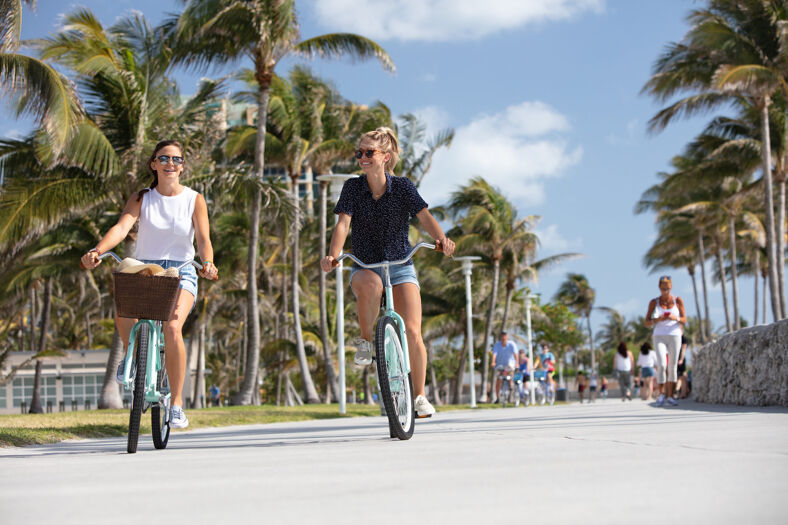 Two women ride bikes in Lummus Park, Miami, Florida.