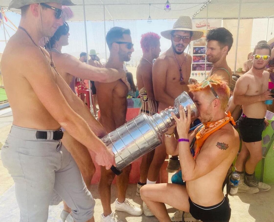 Veteran bromosexual Burner Bam Bam chugging beer from a Stanley Cup replica at the queer camp  Glamcocks. 