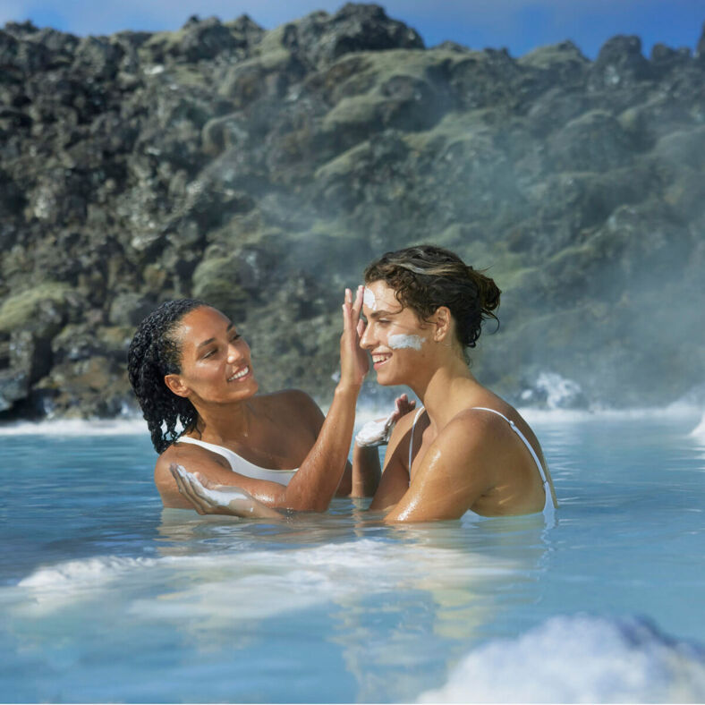 Two women applying face masks at the Blue Lagoon in Iceland.