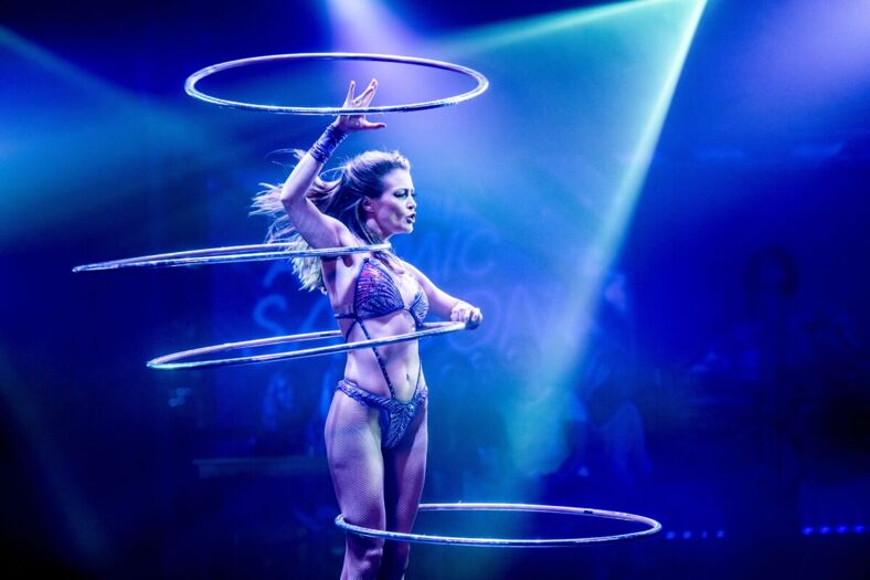 A fit woman works four different hula-hoops around her body