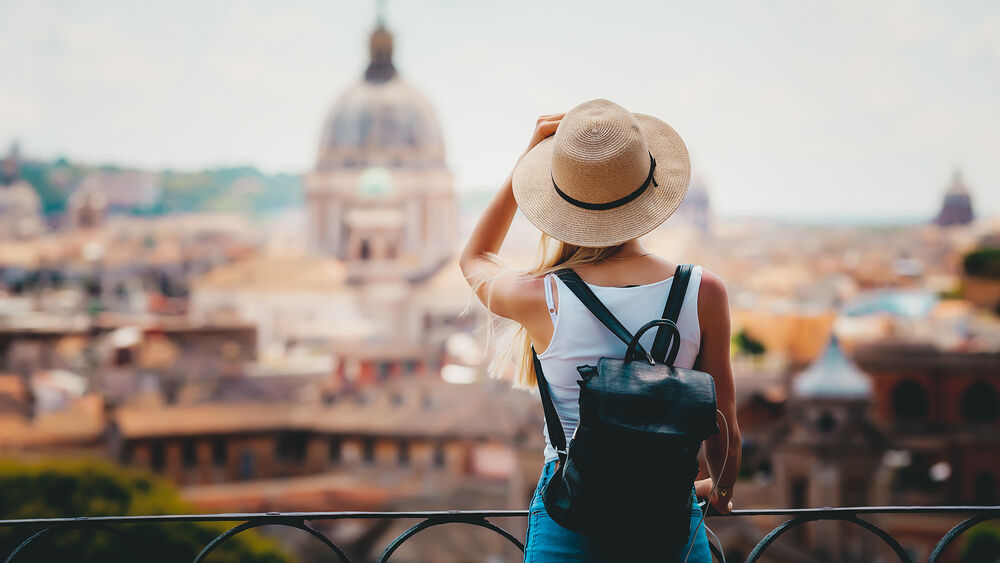 Rome Europe Italia travel summer tourism holiday vacation background -young smiling girl with mobile phone camera and map in hand standing on the hill looking on the cathedral Vatican
