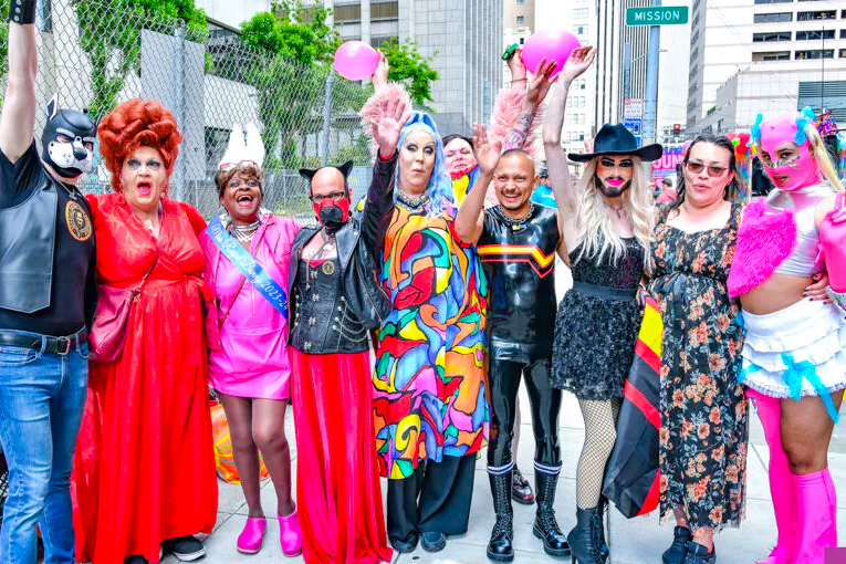 A diverse group of people, drag queens, pups, lesbians, latex and leather lovers converge on a street in San Francisco for a group photo.