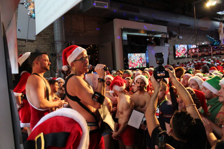 Sidetrack manager Bradley Thomas making announcements and explaining rules of Santa Speedo Run