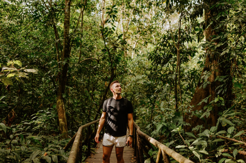 Man standing on a pathway in a jungle.