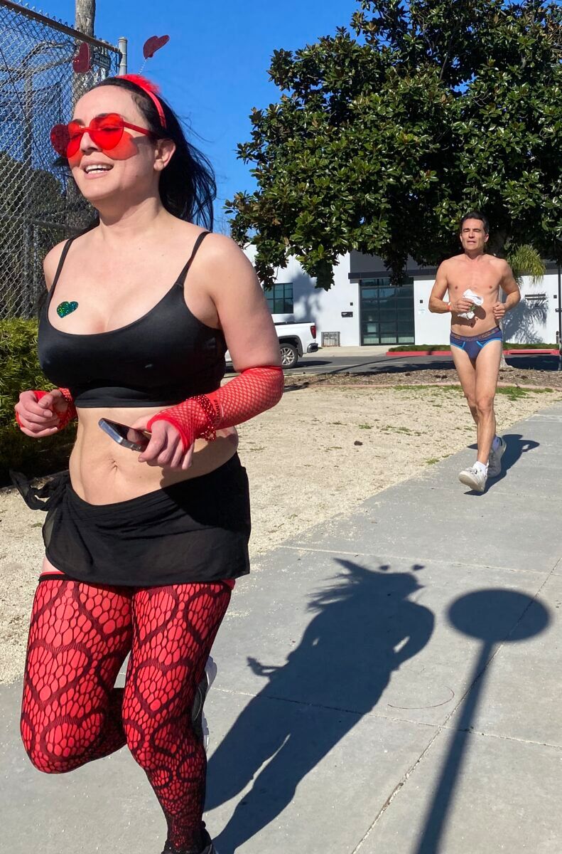 A female runner and male runner in briefs.