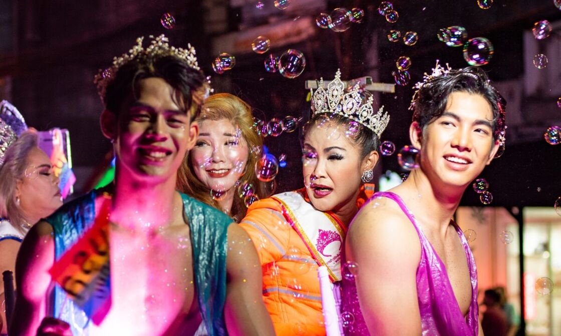 A group of individuals in colorful lights, surrounded by bubbles at the 2022 Chiang Mai LGBTQ Pride Parade in Thailand