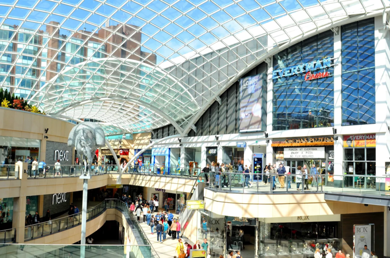 Trinity Leeds Mall in Leeds, England, filled with shoppers on a sunny day.