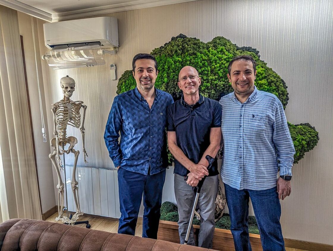 Brent stands with his doctors in their office at a post-surgery visit.