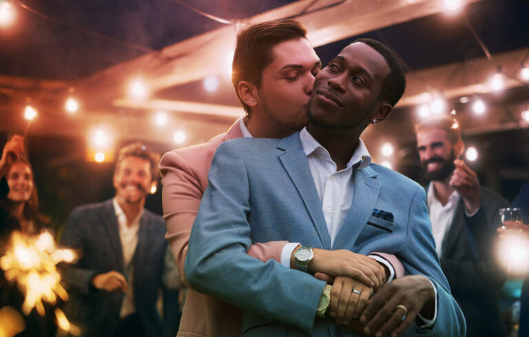 Two men embrace at a party.