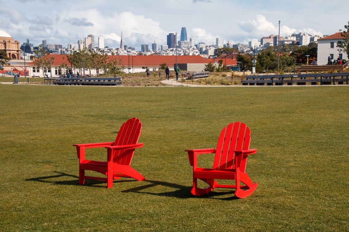Two red rocking chairs sit in the grass at Tunnel Tops Park