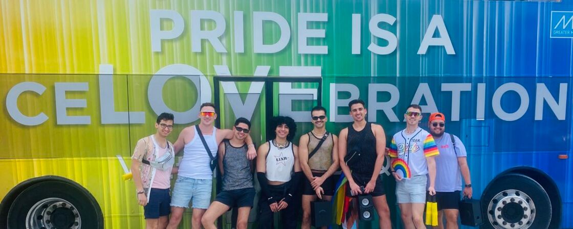 A gaggle of of young Miami gays posing in front of the Great Miami COnvention & Visotors Bureau float before the parade.